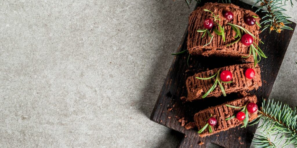 Une buche de Noël, servie et tranchée sur une planche à découper en bois